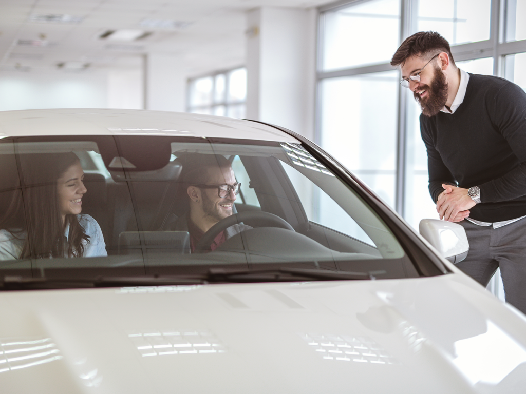 a couple talking with a car salesperson.